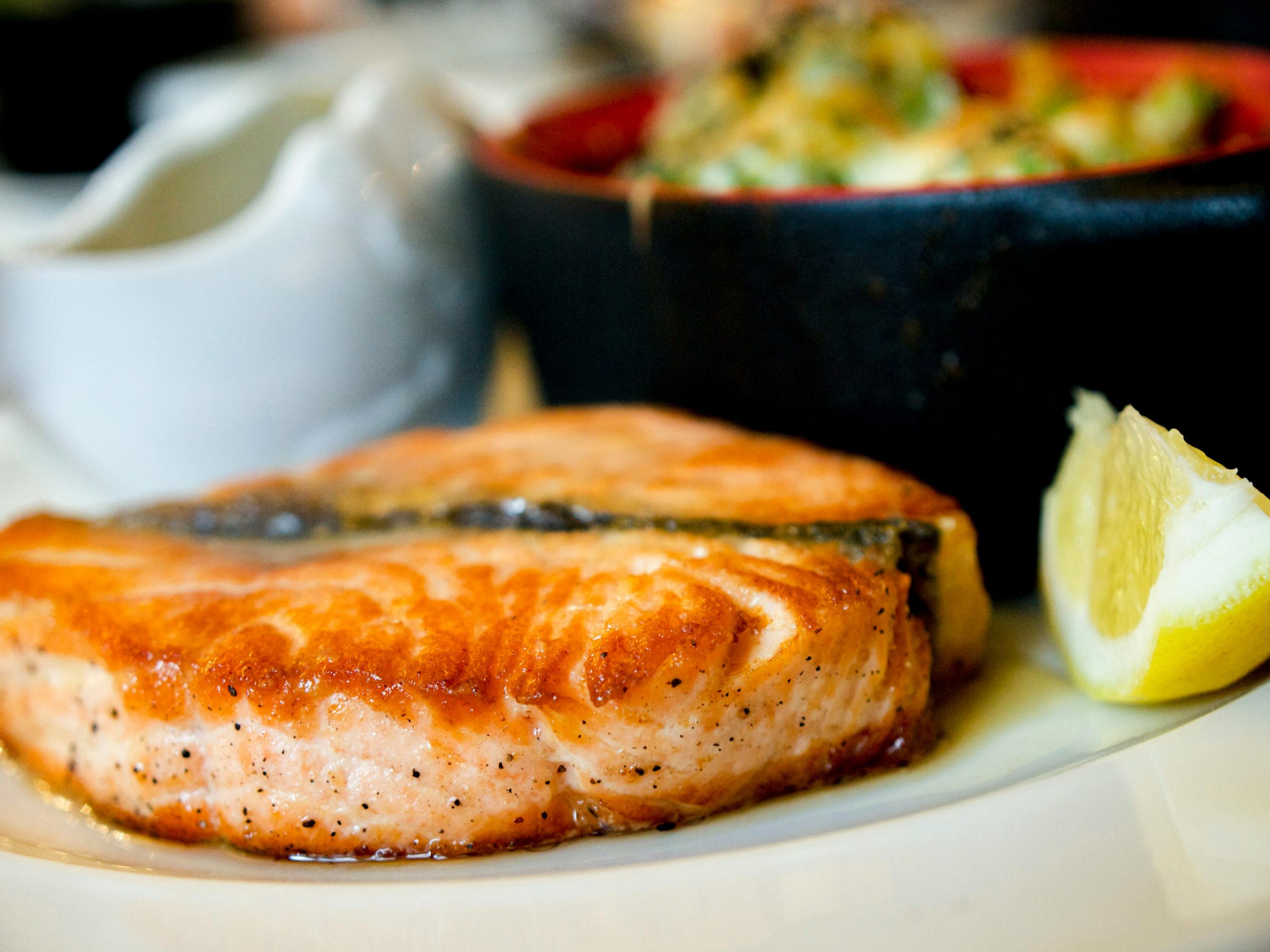 grilled salmon with a bowl of vegetables on the side